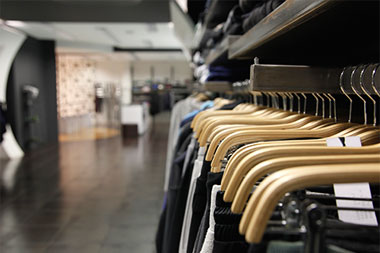 Clothes hanging on a clothing rack in a department store. 