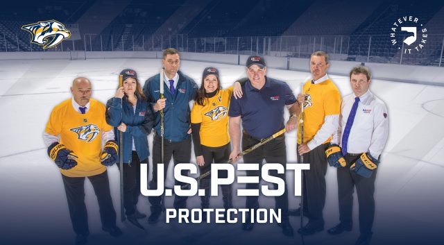 The U.S. Pest Protection team posing on an ice hockey rink wearing Nashville Predators gear.