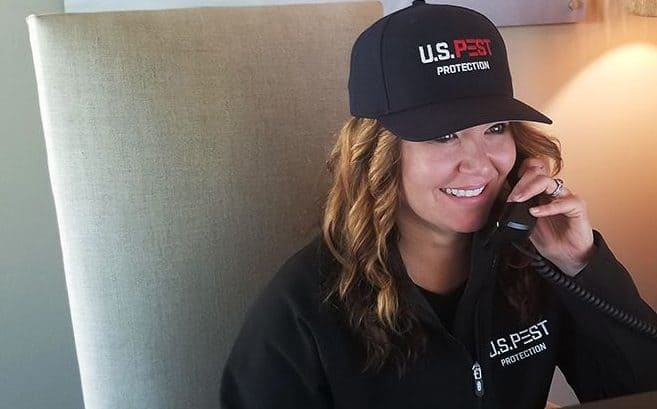 A U.S. Pest Protection customer service member smiling on the phone.