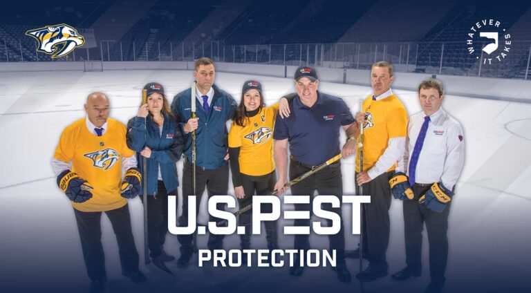 US Pest Erica and JK Brister standing on the hockey rink with Tennessee Predators owners and other members.