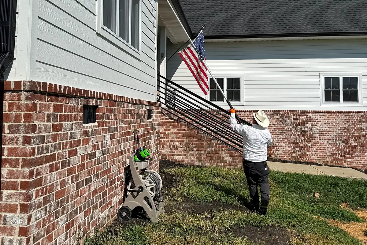 U.S. Pest Protection technician performing a late-summer perimeter inspection at a residential home