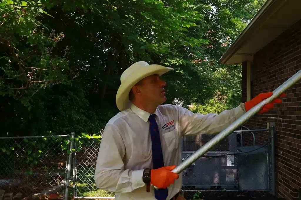 Things We Changed in Our Own Yard After J.K. Got Sick 3 U.S. Pest Protection technician treating a wooded yard edge with outside rig equipment for tick control