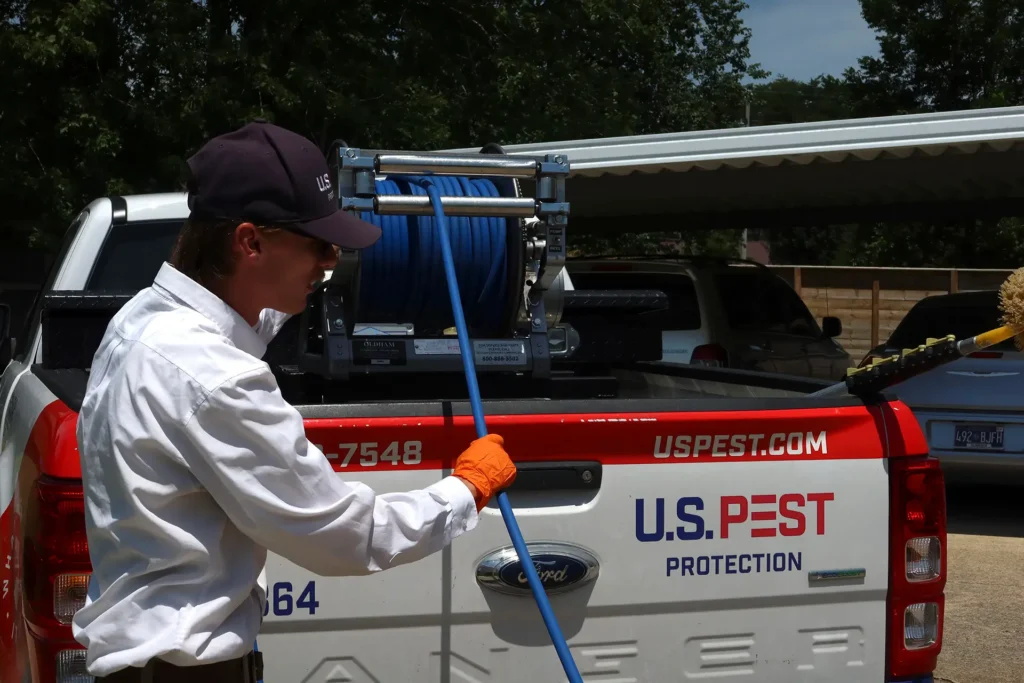 U.S. Pest Protection technician treating a residential yard perimeter for lone star tick control