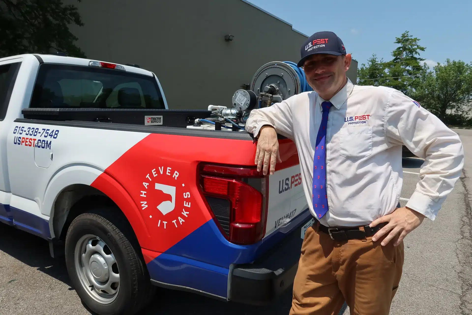 U.S. Pest Protection technician standing beside a branded pest control service truck