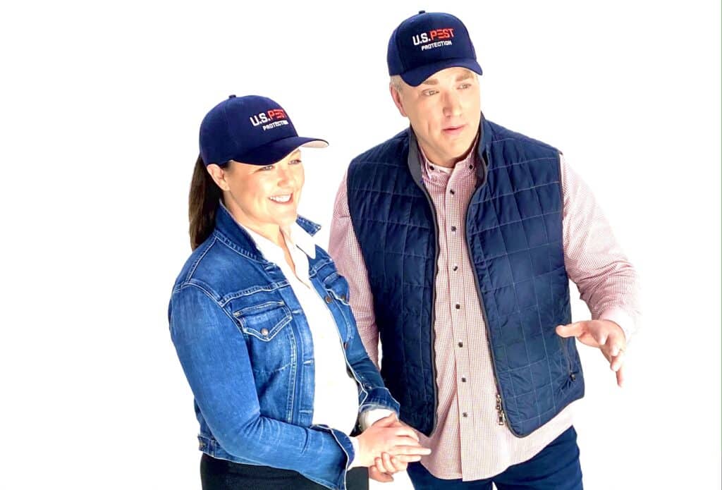 Erica Brister and J.K. Brister of U.S. Pest Protection, wearing U.S. Pest caps